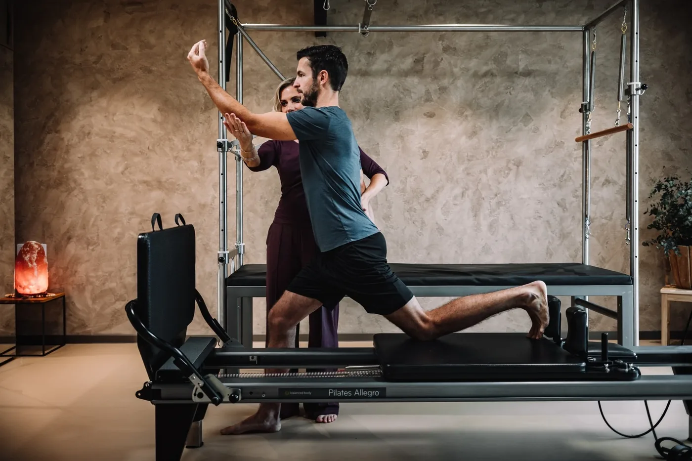 Lektorka vede klientovi paži do výpadu na pilates reformeru před cadillacem